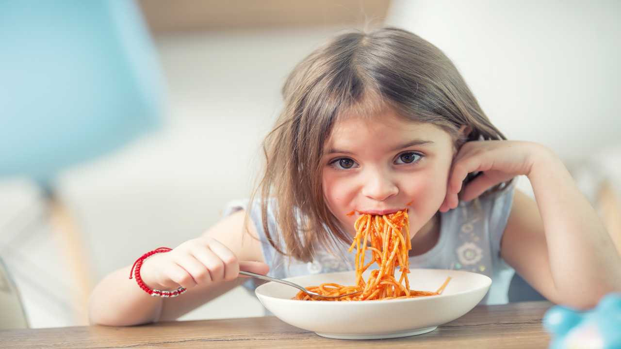 bambina mangia spaghetti