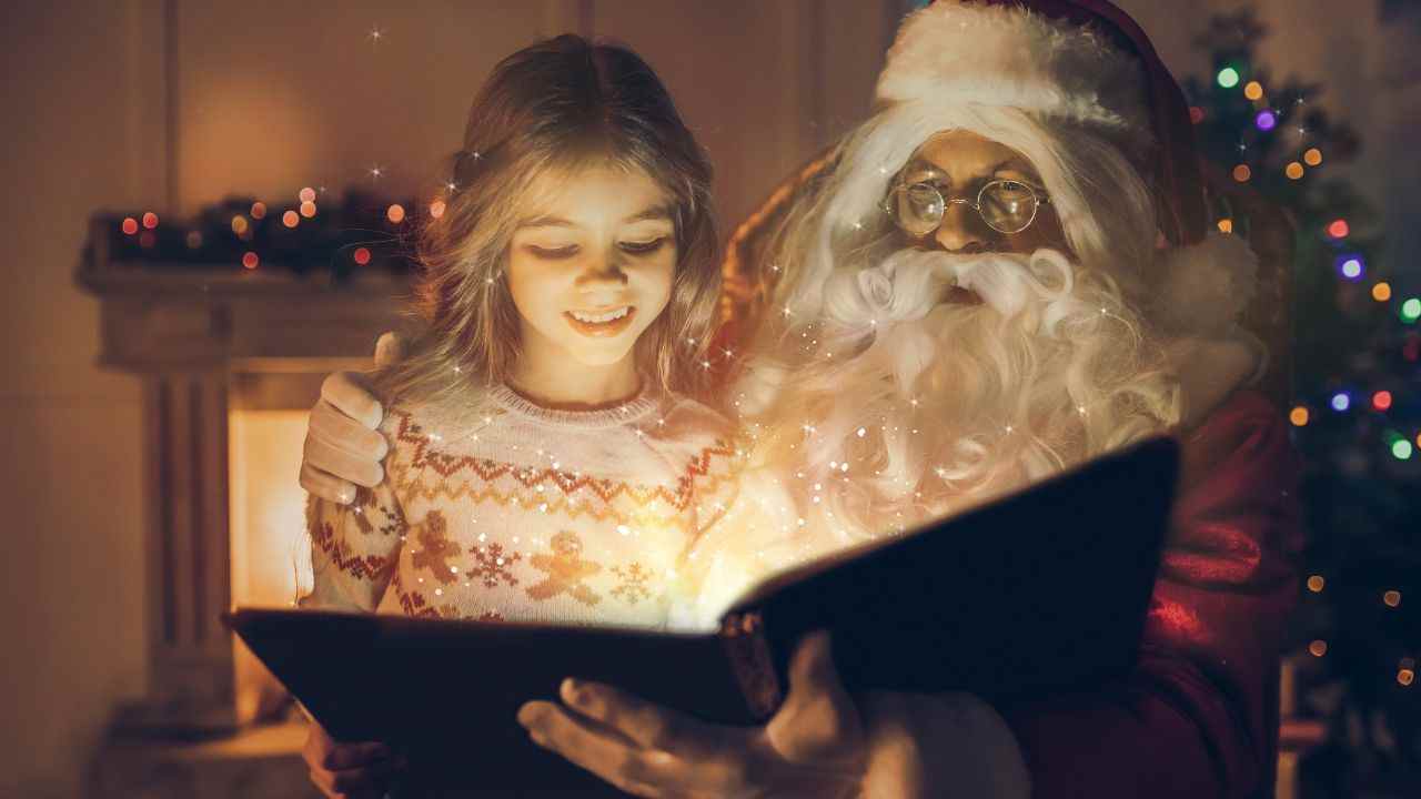 Babbo Natale legge un libro in compagnia di una bambina