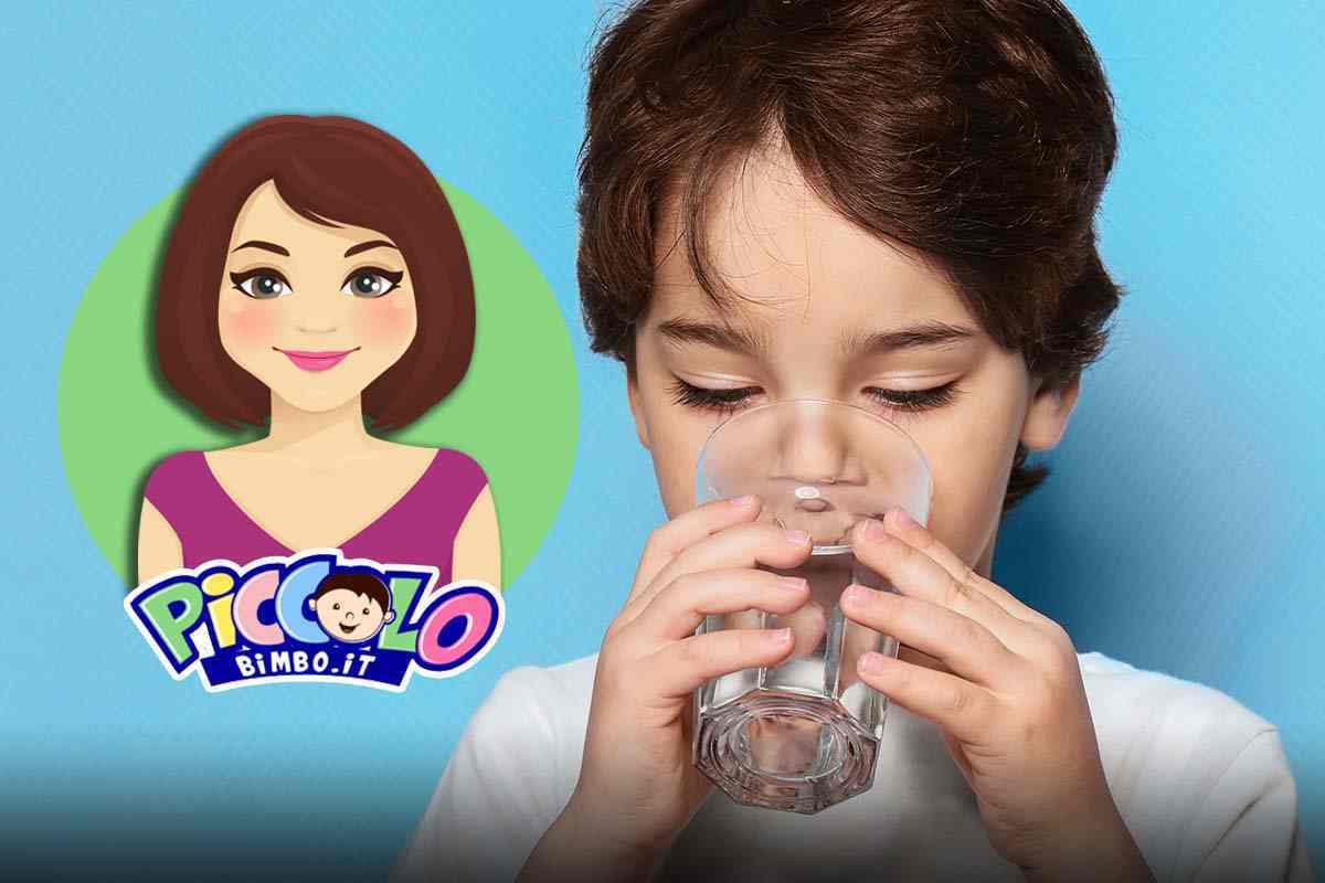bambino beve un bicchiere d'acqua